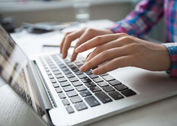 Cropped view of person hands typing on laptop computer