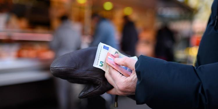 05 March 2022, Hamburg: A woman stands in line at a stall holding the cash for her purchase. Inflation in the euro zone has risen to a record high, driven by energy costs. Photo: Jonas Walzberg/dpa (Photo by Jonas Walzberg / DPA / dpa Picture-Alliance via AFP)