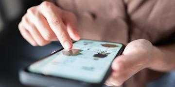 Woman online shopping on smart phone fashion clothes at home