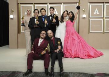 Jamie Lee Curtis, from back left, Ke Huy Quan, James Hong, Jonathan Wang, Michelle Yeoh, and Stephanie Hsu, Daniel Kwan, left front, and Daniel Scheinert, winners of the award for best film for "Everything Everywhere All at Once," pose in the press room at the Oscars on Sunday, March 12, 2023, at the Dolby Theatre in Los Angeles. (Photo by Jordan Strauss/Invision/AP)