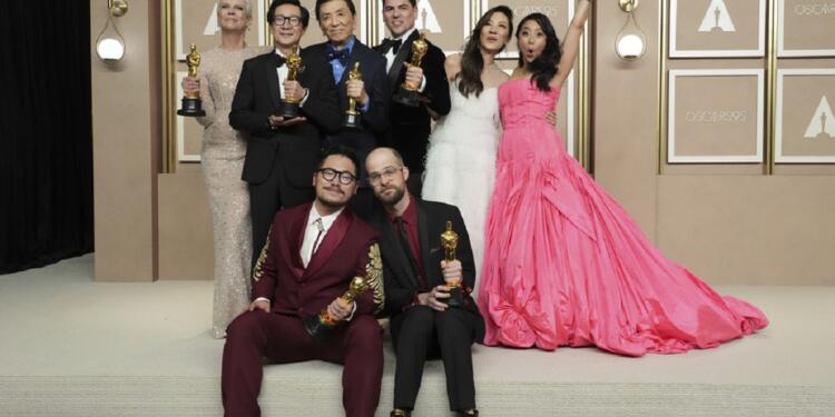 Jamie Lee Curtis, from back left, Ke Huy Quan, James Hong, Jonathan Wang, Michelle Yeoh, and Stephanie Hsu, Daniel Kwan, left front, and Daniel Scheinert, winners of the award for best film for "Everything Everywhere All at Once," pose in the press room at the Oscars on Sunday, March 12, 2023, at the Dolby Theatre in Los Angeles. (Photo by Jordan Strauss/Invision/AP)