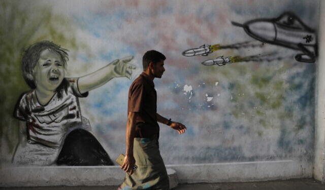 epa10557338 A Yemeni passes graffiti sprayed on a wall depicting a child victim of Yemen's war, on the first anniversary of a UN-brokered truce, in Sana'a, Yemen, 03 April 2023. Yemen continues to experience its longest lull in fighting since the UN-brokered truce between the Yemeni government and the Houthis started on 02 April 2022, despite the warring parties failure to renew the truce in October 2022. Yemen’s war is referred to as the Saudi Arabia-Iran proxy conflict in which the warring parties have been militarily and politically backed by Saudi Arabia and Iran respectively since 2015.  EPA/YAHYA ARHAB