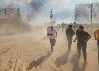 Palestinians take down the fence on the Israel-Gaza border to enter Israel during the surprise attack on Oct. 7. HANI ALSHAER/ANADOLU AGENCY VIA GETTY IMAGES