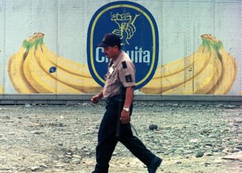 A dock worker at Almirante port on Panama's Atlantic coast walks past containers with the logo of multinational fruit company Chiquita, October 10, 2002. The containers will be shipped full of bananas to Europe. After 100 years in Panama, Chiquita is considering closing its operations because of mounting losses, especially at its Pacific plantations. REUTERS/Alberto Lowe/FEATURE TO MATCH STORY FOOD-PANAMA-BANANAS