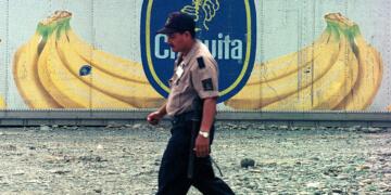 A dock worker at Almirante port on Panama's Atlantic coast walks past containers with the logo of multinational fruit company Chiquita, October 10, 2002. The containers will be shipped full of bananas to Europe. After 100 years in Panama, Chiquita is considering closing its operations because of mounting losses, especially at its Pacific plantations. REUTERS/Alberto Lowe/FEATURE TO MATCH STORY FOOD-PANAMA-BANANAS
