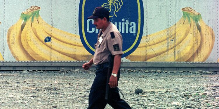 A dock worker at Almirante port on Panama's Atlantic coast walks past containers with the logo of multinational fruit company Chiquita, October 10, 2002. The containers will be shipped full of bananas to Europe. After 100 years in Panama, Chiquita is considering closing its operations because of mounting losses, especially at its Pacific plantations. REUTERS/Alberto Lowe/FEATURE TO MATCH STORY FOOD-PANAMA-BANANAS